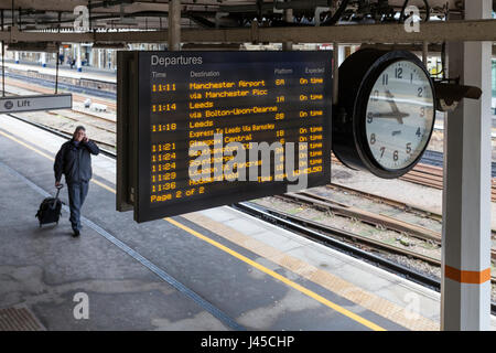 Train destination board with departure times and platform number, and station clock, Sheffield Railway Station, Sheffield, England, UK Stock Photo