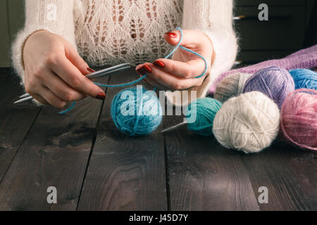 woman is knitting on a kitchen table Stock Photo