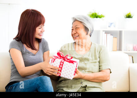 happy  young woman giving  present to grandmother Stock Photo