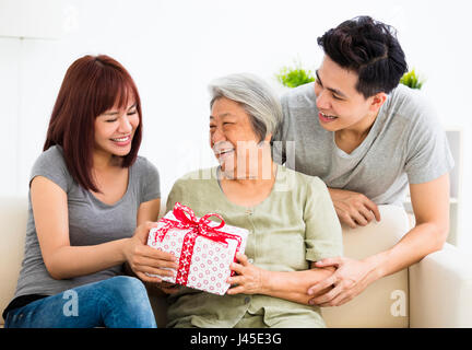 happy  young couple giving  present to grandmother Stock Photo