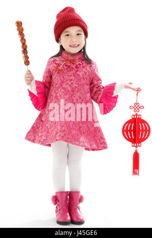 Happy little girl eating Tomatoes on sticks Stock Photo