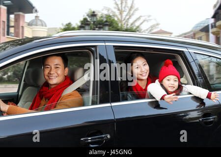 A happy family is sitting in a car. Stock Photo
