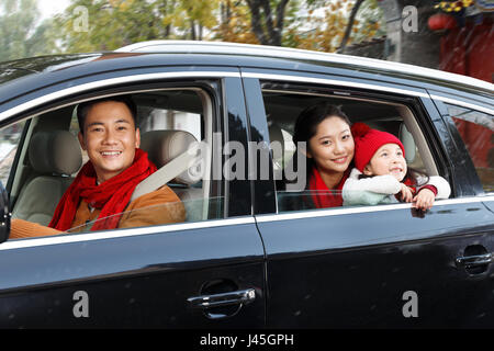 A happy family is sitting in a car. Stock Photo