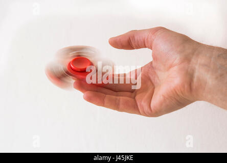 Hand spinner fidget finger toy spinning on a finger Stock Photo