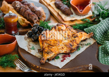 Roast chicken with vegetables and sauce on a served table. Traditional Georgian dinner Stock Photo