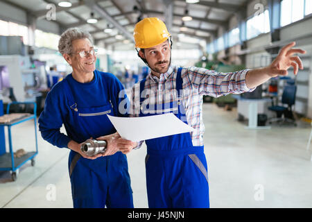 Team Of Engineers Having Discussion In Metal Factory Stock Photo