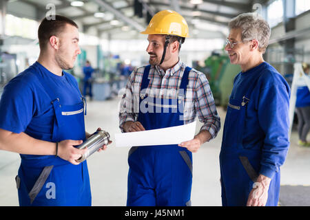 Team Of Engineers Having Discussion In Metal Factory Stock Photo
