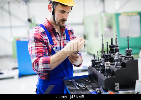 modern industrial machine operator working in metal industry factory Stock Photo