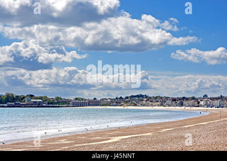 Weymouth beach -Dorset panoramic view  sweeping vista of seafront - attractive town beyond - early summer sunlight - blue sea and cloud flecked sky Stock Photo
