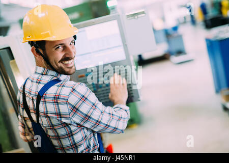 Industry Worker working on cnc machine in metal industry factory Stock Photo