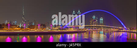 DUBAI, UAE - MARCH 27, 2017: The evening skyline with the arched bridge over the new Canal and Downtown. Stock Photo