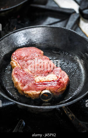 Raw steak in frying pan with meat thermometer Stock Photo