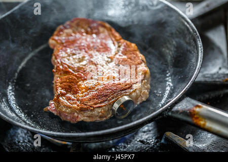 Grilled pork steak with meat thermometer in a frying pan Stock Photo