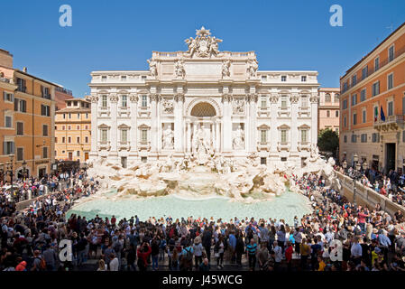 An aerial view of The Trevi Fountain 'Fontana di Trevi' in Rome with crowds of tourists and visitors on a sunny day with blue sky. Stock Photo