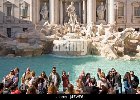 The Trevi Fountain 'Fontana di Trevi' in Rome with crowds of tourists and visitors on a sunny day with blue sky. Stock Photo