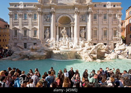 The Trevi Fountain 'Fontana di Trevi' in Rome with crowds of tourists and visitors on a sunny day with blue sky. Stock Photo