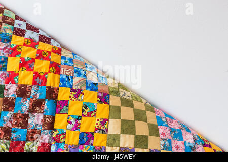homemade, patchwork, quilting, sewing, comfort concept - multicolored handmaded blanket in best russian traditions made of textile squares with floral and abstract prints. with empty space for text Stock Photo