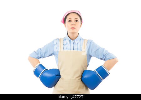 Strong house woman boss concept. Confident attitude young mixed race housewife standing intimidating wearing boxing gloves ready for the competition.  Stock Photo