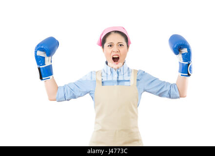 Mad mixed race asian chinese housewife angry showing aggressive female flexing muscles wearing boxing gloves hands up isolated on white background. Stock Photo