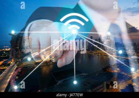 Businessman push wifi icon on city and network connection concept. Singapore smart city and wireless communication network, abstract image visual, int Stock Photo