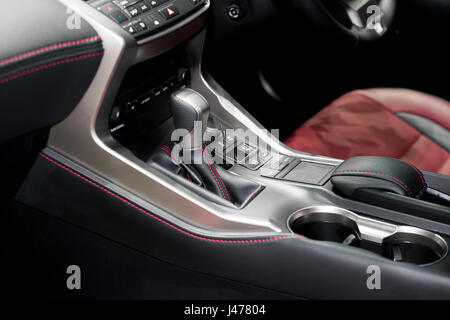 Red luxury car Interior with steering wheel, shift lever and air condition and radio button control in car Stock Photo