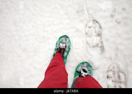 Hiker in snowshoes on snow. First person view. Stock Photo