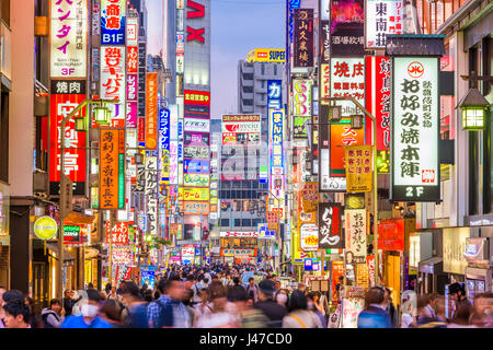TOKYO, JAPAN - MAY 7, 2017: Crowds pass through Kabukicho in the Shinjuku district. The area is an entertainment and red-light district. Stock Photo