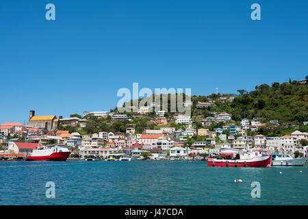 Boats in the Carenage surrounded by colourful buildings on a hill in St. George's, capital of Grenada, West Indies, Caribbean Stock Photo