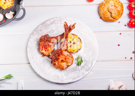 Close up Gourmet Grilled veal loin Steak Meat with grilled lemon on a white plate, Served on Top of a Rustic woodden white Table. Captured in High Ang Stock Photo