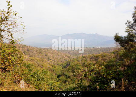 a view of the mountains and acacia forests of morni hills nature reserve near chandigarh punja india with sandy hills and mist under a cloudy sky in s Stock Photo