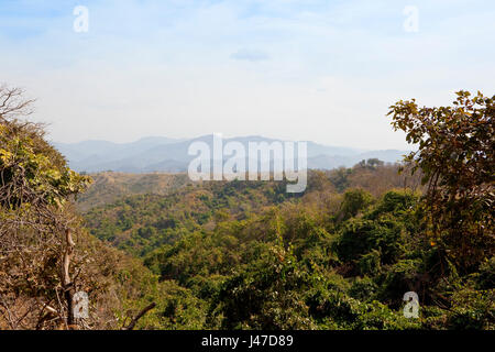 a view of the mountain landscape of morni hills nature reserve near chandigarh in punjab india with acacia forest and sandy hills under a blue cloudy  Stock Photo