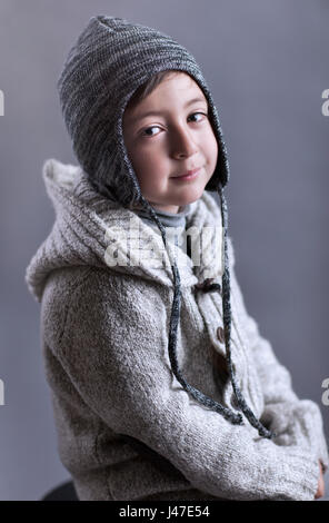 Cute little boy wearing a gray Iceland Finnish Lapland knitted cap hat and a grey kitted sweater Stock Photo