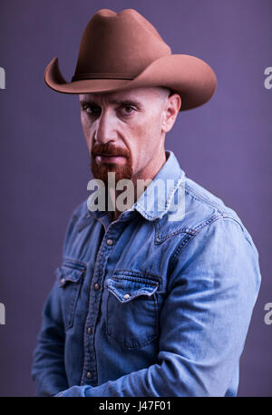 Cowboy with Red Goatee in Blue Levi denim chambray shirt and Stetson Cowboy hat Stock Photo