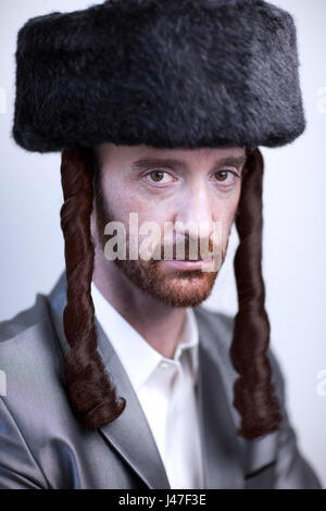 Handsome Orthodox Jewish man Hasidim rabbi with red beard in a large