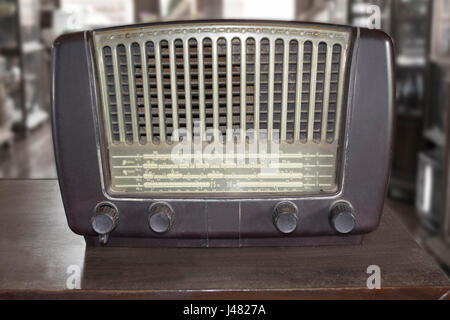 Old retro radio on wooden table in antique store. Stock Photo