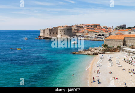 Tourists and locals enjoy the late springtime sunshine on the upmarket Banje Beach adjacent to the old town of Dubrovnik. Stock Photo