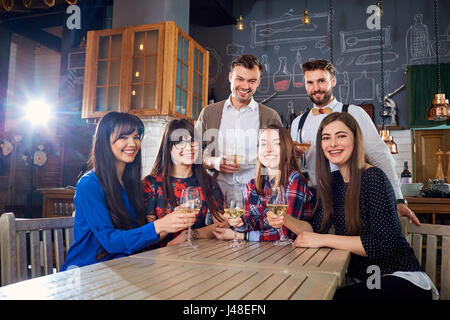 Group of friends at a meeting with glasses laugh and smile Stock Photo