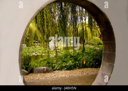 View through the 'Moongate', a circular portal the lake beyond at the 'Chinese Garden of Friendship',Darling Harbour precinct, Sydney, Australia Stock Photo