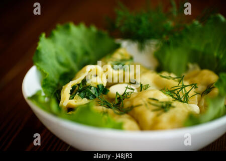 Dumplings stuffed with potatoes with green onions in a plate Stock Photo