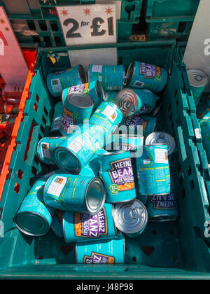 Display of damaged tins of Heinz baked beans and pork sausages for sale on a stall at a weekly market in North Yorkshire priced two fir £1