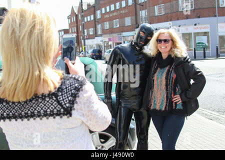 Maldon, Essex, UK. 10th May, 2017. The Gimp Man of Essex appears in the Essex town of Maldon. The mysterious character dressed from head to toe in black latex was seen walking up and down Maldon High Street. The Gimp Man donates a £1 to the mental health charity Mind for each selfie that is taken with him and their was no shortage of people who had their picture taken. Credit: David Johnson/Alamy Live News Stock Photo