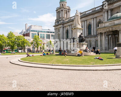 Belfast, Northern Ireland, UK, 11th May 2017. UK weather: With the temperature hovering around 20C people relax in the early afternoon sunshine in the grounds of the City Hall. Credit J Orr/Alamy Live News Stock Photo