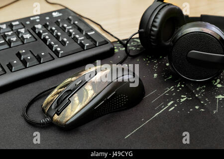 On the desktop are the computer keyboard, headphones, computer mouse on the Mat. Stock Photo
