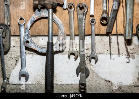 On the wall in the garage hanging on a set of old tools for plumbing work. Stock Photo