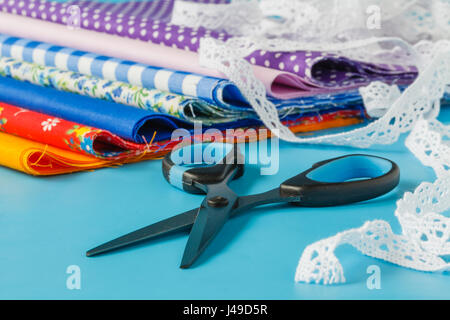 Sewing and Needlework: thread, needles, lace, ribbon, scissors, cloth. Stock Photo