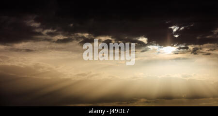 Light beams shining trough the clouds at sunset Stock Photo