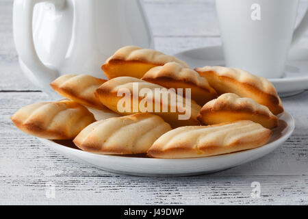 chocolate chip madeleines and coffee on a wooden board Stock Photo