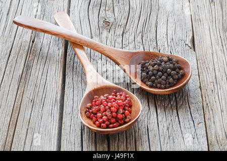 Colored pepper in a vintage wooden spoon on table Stock Photo