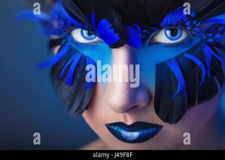 Beautiful woman with make-up with blue feathers Stock Photo