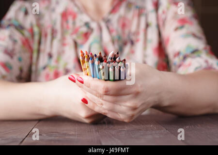 Bunch of colored pencil in woman hands, art design concept Stock Photo